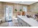 Bathroom with tan tile, a white sink, toilet, and a door to the outside at 1990 59Th N St, St Petersburg, FL 33710