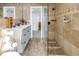 Elegant bathroom featuring travertine tile, glass shower, and a vanity with white countertops at 1990 59Th N St, St Petersburg, FL 33710