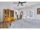 Bright bedroom featuring a ceiling fan, wood-look flooring, a display cabinet, and French door access to the outside at 1990 59Th N St, St Petersburg, FL 33710