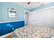 Bright bedroom featuring blue walls, white trim, and a colorful handmade quilt on the bed at 1990 59Th N St, St Petersburg, FL 33710