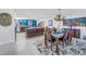 Open-concept dining room and kitchen area with tile flooring, a rustic chandelier, and a large island at 1990 59Th N St, St Petersburg, FL 33710