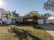 Charming single-story home with well-maintained lawn, lush landscaping, and a paved driveway at 1990 59Th N St, St Petersburg, FL 33710