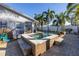 A hot tub in a backyard with palm trees, outdoor seating, and a view of the home at 1990 59Th N St, St Petersburg, FL 33710