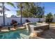 Backyard patio with hot tub, mature landscaping, and views of the fence and greenery at 1990 59Th N St, St Petersburg, FL 33710
