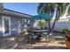 Outdoor patio with dining set, blue umbrella, pavers, and potted plants near the house at 1990 59Th N St, St Petersburg, FL 33710