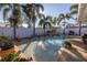 Lovely backyard featuring a pool with a fountain, tropical palms, and white fence at 1990 59Th N St, St Petersburg, FL 33710