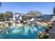 Backyard pool and patio area with chairs, potted plants, and a seating area under a blue umbrella at 1990 59Th N St, St Petersburg, FL 33710
