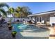 Sparkling pool with a stone waterfall feature surrounded by lush landscaping and a paver patio at 1990 59Th N St, St Petersburg, FL 33710