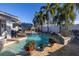 Relaxing backyard with a pristine pool, patio seating, tropical plants, and a white fence at 1990 59Th N St, St Petersburg, FL 33710