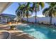 Inviting backyard pool surrounded by palm trees, patio, and outdoor dining area at 1990 59Th N St, St Petersburg, FL 33710