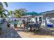 Outdoor living space showcasing pool, patio, dining table with umbrella, and manicured landscaping at 1990 59Th N St, St Petersburg, FL 33710