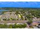 A bird's-eye view highlights modern townhomes near a road, surrounded by lush greenery and a distant waterfront at 2013 Sunset Wind Loop, Oldsmar, FL 34677