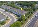 Aerial view of bright, inviting townhomes with blue accents and a well-maintained landscape, situated near a road at 2013 Sunset Wind Loop, Oldsmar, FL 34677