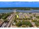 This aerial shot shows townhomes close to a waterfront and bridge, and surrounded by trees, offering serene living at 2013 Sunset Wind Loop, Oldsmar, FL 34677