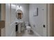 Bathroom features a pedestal sink, oval mirror, and elegant decor, exuding a clean and modern aesthetic at 2013 Sunset Wind Loop, Oldsmar, FL 34677