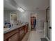 Bathroom with double sinks, granite countertop, and walk-in closet offers space and convenience at 2013 Sunset Wind Loop, Oldsmar, FL 34677