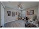 Charming bedroom featuring light gray walls, stylish ceiling fan, gray laminate flooring, and artistically decorated walls at 2013 Sunset Wind Loop, Oldsmar, FL 34677