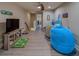 A bonus room with hardwood floors and a ceiling fan features a large TV and casual seating for relaxing at 2013 Sunset Wind Loop, Oldsmar, FL 34677
