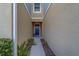 Inviting front entrance with warm stucco walls, a blue door, and neatly landscaped planters on both sides at 2013 Sunset Wind Loop, Oldsmar, FL 34677