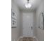 Clean, neutral hallway with a white door, tiled floor, modern art, and decorative mirror at 2013 Sunset Wind Loop, Oldsmar, FL 34677