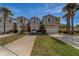 Charming townhomes featuring two-car garages, beautiful landscaping, and inviting curb appeal with lovely palm trees at 2013 Sunset Wind Loop, Oldsmar, FL 34677