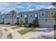 Attractive two-story townhome featuring a blue and yellow exterior, attached garages, and meticulously maintained landscaping at 2013 Sunset Wind Loop, Oldsmar, FL 34677