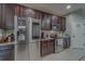 Modern kitchen featuring stainless steel appliances, dark wood cabinets, granite countertops, and tile backsplash at 2013 Sunset Wind Loop, Oldsmar, FL 34677