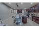 Wide view of the kitchen island and dark wood cabinetry, flowing to an adjacent entryway at 2013 Sunset Wind Loop, Oldsmar, FL 34677