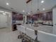 Spacious kitchen featuring a large granite island with bar stools, dark cabinets, and stainless steel appliances at 2013 Sunset Wind Loop, Oldsmar, FL 34677