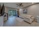 Bright living room with sliding glass doors to the backyard, tile flooring, and a comfortable seating area at 2013 Sunset Wind Loop, Oldsmar, FL 34677