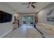 Stylish living room with modern decor, tile floors, and access to a screened patio with natural light at 2013 Sunset Wind Loop, Oldsmar, FL 34677