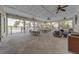 Inviting pool pavilion features multiple ceiling fans, tables, chairs, and comfortable lounge furniture at 2013 Sunset Wind Loop, Oldsmar, FL 34677