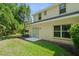 Charming backyard with a well-maintained lawn, patio and sliding glass door leading into the home at 20221 Vintage Oaks Pl, Tampa, FL 33647