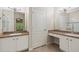Bathroom featuring dual sinks, vanity area, tile floors, and a separate toilet room at 20221 Vintage Oaks Pl, Tampa, FL 33647