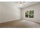 Cozy bedroom featuring neutral carpeting and a large window with a view of lush greenery at 20221 Vintage Oaks Pl, Tampa, FL 33647