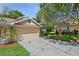 Single-Gathering home featuring a two-car garage, neutral exterior paint, and well-maintained landscaping at 20221 Vintage Oaks Pl, Tampa, FL 33647