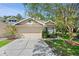 Charming single-Gathering home featuring a two-car garage, manicured landscaping and neutral exterior paint at 20221 Vintage Oaks Pl, Tampa, FL 33647