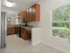 Bright kitchen with wood cabinets, stainless appliances, and a view of the backyard through a large window at 20221 Vintage Oaks Pl, Tampa, FL 33647