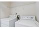 Functional laundry area features a washer and dryer with a shelf above, providing ample space for laundry needs at 20221 Vintage Oaks Pl, Tampa, FL 33647