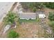 Aerial view of a one-story house, and storage shed, in a spacious yard with mature trees at 20413 Keene Rd, Wimauma, FL 33598