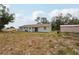 A single-story home with a well-maintained lawn and a storage shed in the backyard at 20413 Keene Rd, Wimauma, FL 33598