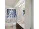 Clean bathroom with a shower-tub combo, toilet, vanity, and decorative shower curtain at 20413 Keene Rd, Wimauma, FL 33598