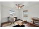 Bright bedroom featuring two windows, ceiling fan, and stylish decor showcasing modern furnishings at 20413 Keene Rd, Wimauma, FL 33598