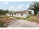 A single-story home, showcasing a well-maintained exterior and manicured landscaping at 20413 Keene Rd, Wimauma, FL 33598
