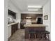 Efficient kitchen with dark cabinetry, breakfast bar, tile floors, and a practical layout for easy cooking at 20413 Keene Rd, Wimauma, FL 33598