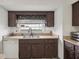 Kitchen area showcasing wooden cabinets, dual sink, window, countertop space, and white dishwasher at 20413 Keene Rd, Wimauma, FL 33598