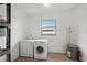 Spacious laundry room with washer, freezer, utility sink, and water heater at 20413 Keene Rd, Wimauma, FL 33598