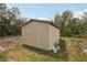 A backyard storage shed with double doors, complemented by surrounding greenery at 20413 Keene Rd, Wimauma, FL 33598