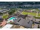 Aerial view of a community center, swimming pool, lawn bowling, lush landscaping, and surrounding residential areas at 2216 W Del Webb Blvd, Sun City Center, FL 33573