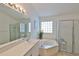 Well-lit bathroom with a soaking tub, separate shower, and a vanity with countertop at 2216 W Del Webb Blvd, Sun City Center, FL 33573